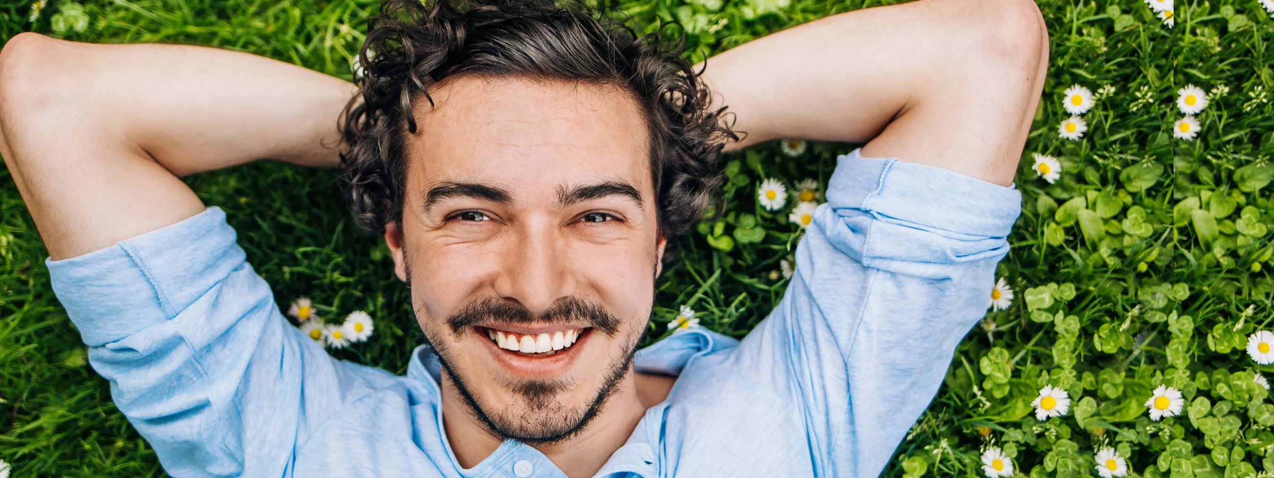 Man smiling and relaxing in the grass